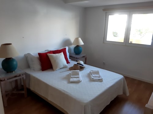 Quarto luminoso no apartamento MARSOL na Praia do Algarve com cama branca, detalhes em vermelho, luminárias duplas e janelas