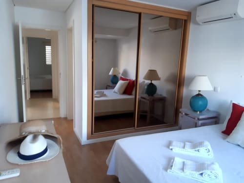 Quarto do apartamento Marsol com guarda-roupa espelhado, duas camas individuais, luminária azul e pisos de madeira no Algarve Beach Holidays