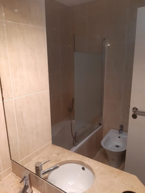Banheiro moderno no apartamento de praia MARSOL em Algarve Beach Holidays com pia redonda, bancada em mármore e chuveiro de vidro