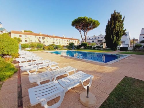 Piscina com espreguiçadeiras brancas no apartamento Algarve Beach Holidays em Praia da Bottelha, Portugal