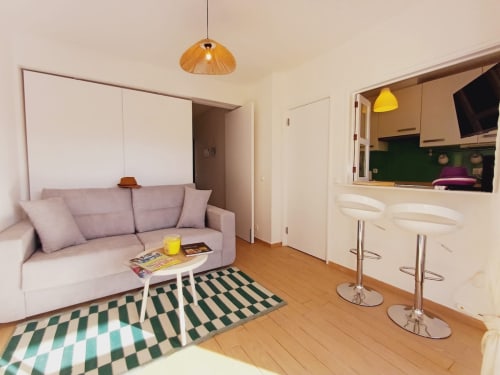 Sala de estar moderna em Algarve Beach Holidays com sofá lavanda, kitchenette e tapete geométrico em Praia da