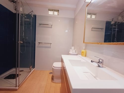 Casa de banho moderna em Algarve Beach Holidays com dupla pia, box de duche e piso em madeira