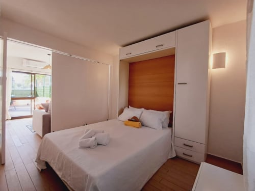 Quarto moderno no apartamento Algarve Beach Holidays em Praia da Botilhão com cama de casal, parede de madeira e terraço