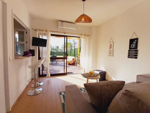 Sala de estar luminosa em Algarve Beach Holidays com mobiliário moderno, terraço com vista para o mar e acabamentos em madeira em Praia