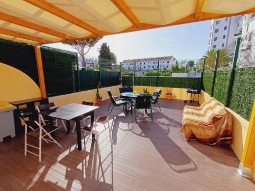 Terraço ensolarado no Algarve Beach Holidays com área de refeições, espreguiçadeiras e vistas da cidade