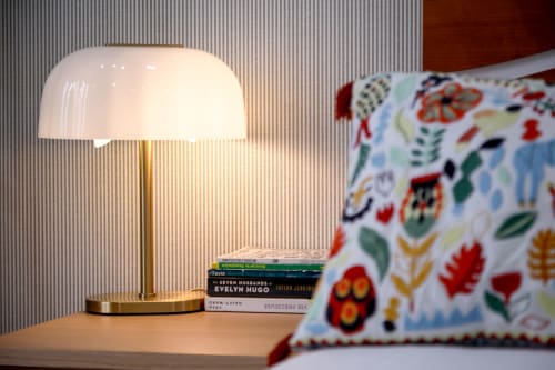 Modern mushroom lamp on wooden nightstand with stacked books at Lisbon Poets Inn hostel