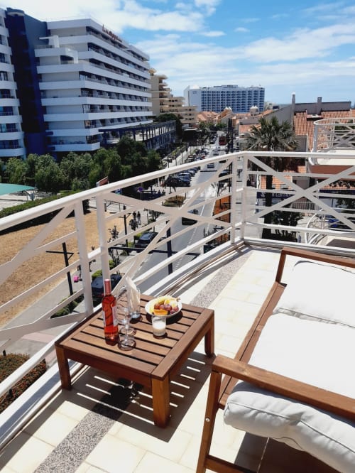Varanda com vista para a praia no Algarve Beach Holidays com móveis de madeira, vista da cidade costeira e apartamentos modernos