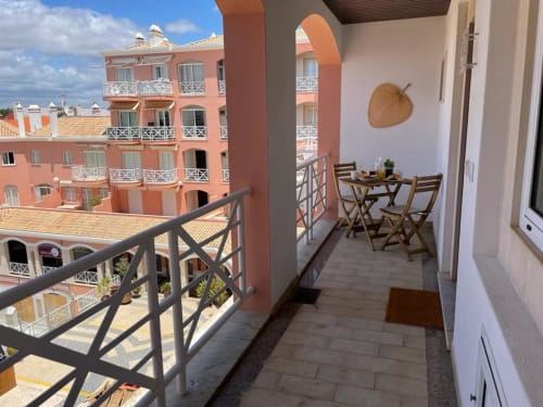 Varanda de apartamento no Algarve com terraço vista para edifícios coloridos de hotel e arquitetura portuguesa