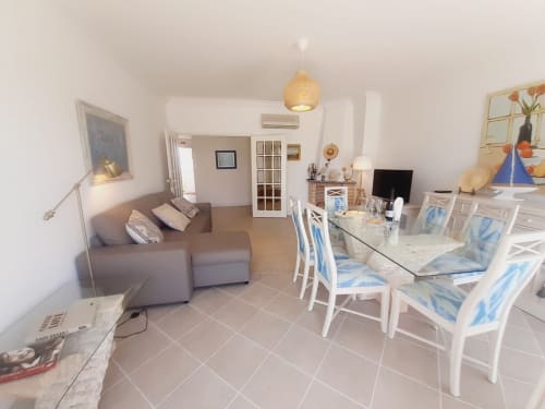Apartamento luminoso de planta aberta na Algarve Beach Holidays com mesa de jantar, sofá e luminária de trama