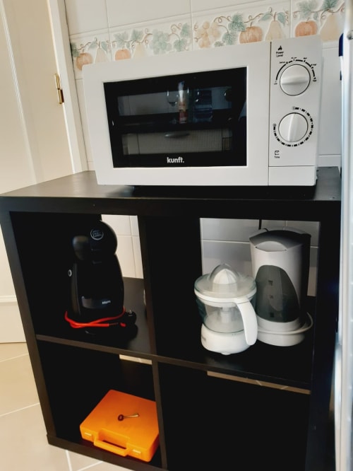 Eletrodomésticos do apartamento Villalusa Beach no Algarve: micro-ondas, cafeteira e utensílios de cozinha.