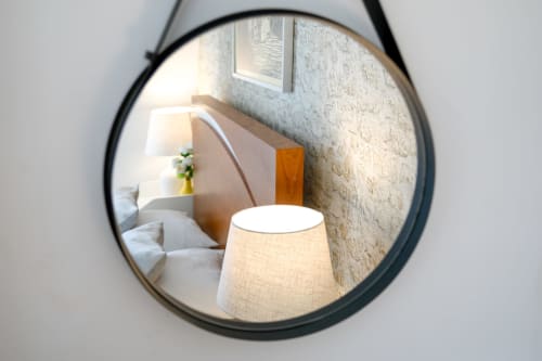 Round mirror reflecting bedroom with lamp at Lisbon Poets Inn hostel, Quarto Casal room with bed and décor