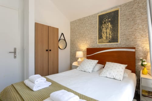 Modern double bedroom at Lisbon Poets Inn with brick accent wall, brown headboard, and contemporary furnishings