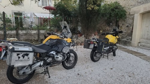 Deux motos d'aventure stationnées dans la cour de la maison d'hôtes Le N°9, Argeliers, France