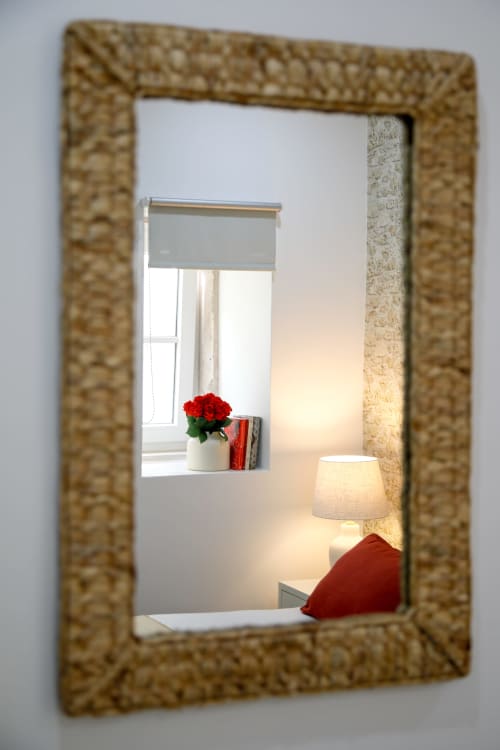 Ornate mirror reflection showing Suite Casal bedroom at Lisbon Poets Inn with red roses, lamp, and red pillow