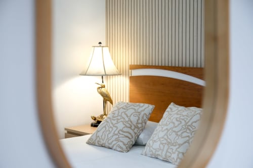 Cozy bedroom at Lisbon Poets Inn with wooden bed, patterned pillows, brass lamp, and modern amenities