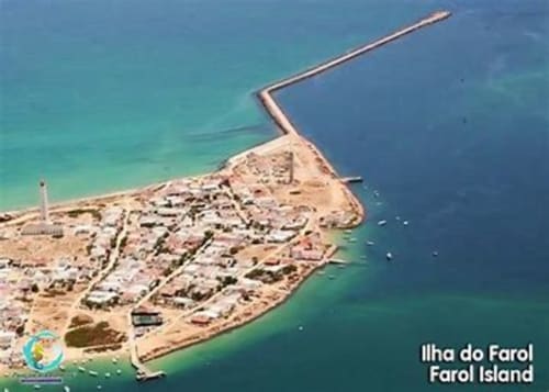 Vista aérea da Ilha do Farol no Algarve com praias arenosas, edifícios e quebra-mar estendendo-se em águas turquesas