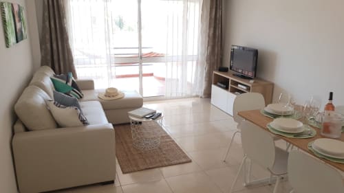 Apartamento luminoso Maresia na Algarve Beach Holidays com sofá bege, área de refeições, TV e vistas da varanda