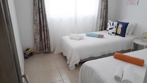 Quarto duplo no apartamento Maresia na Praia do Algarve com camas brancas e vista para a cidade