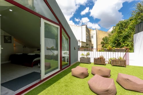Lisbon Poets Inn terrace with bean bags and grass, bedroom visible through glass doors