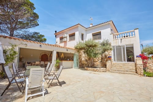Villa mediterránea blanca de Experiencias Encant B&B en Calafat: patio con tumbonas y zona de comedor al aire libre