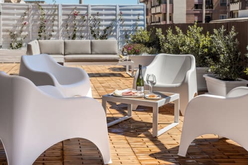 Terrazza panoramica moderna Bluemoon Sardegna con lettini bianchi, divano e piante in vaso con vista su Cagliari