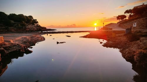 Atardecer en la cala de Calafat con aguas tranquilas, costa rocosa y vistas al Mediterráneo cerca de Experiencias Encant