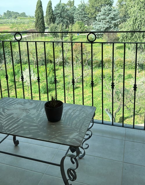 Balcone con vista sul giardino presso AgriBio Villa Ribes, Altamura. Ringhiera in metallo nero affaccia sul paesaggio viticolo con cipressi