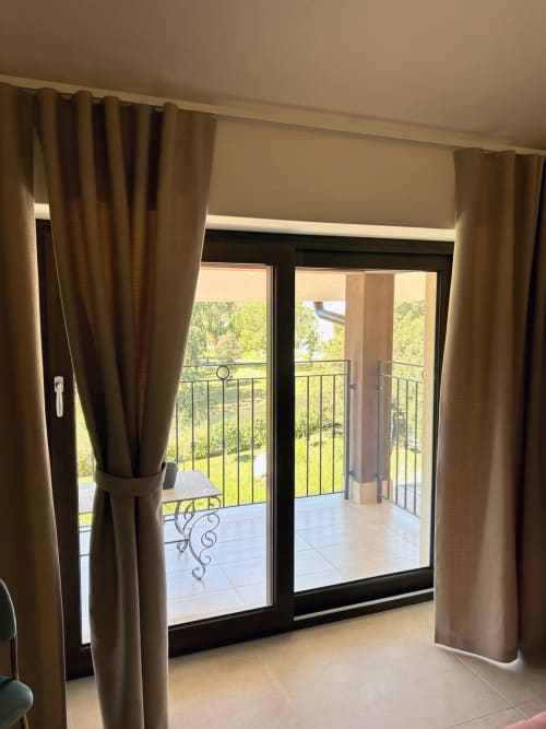 Balconate della stanza Anemone con vista sul giardino di Villa Ribes Agriturismo ad Altamura, con tende beige e ringhiera in metallo