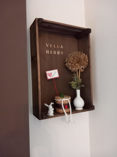 Mensola in legno Villa Ribes con oggetti decorativi, fiori in vaso e cartello a forma di cuore nella guest house di Altamura