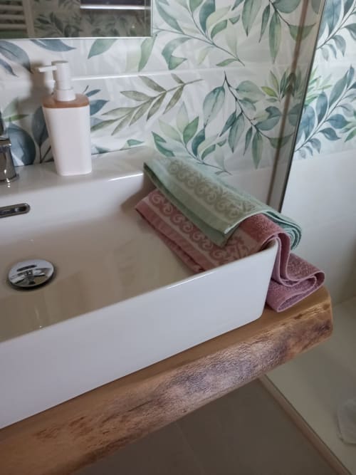 Moderno lavabo in bagno con base in legno, asciugamani ripiegati e accessori per l'igiene presso AgriBio Villa Ribes ad Altamura