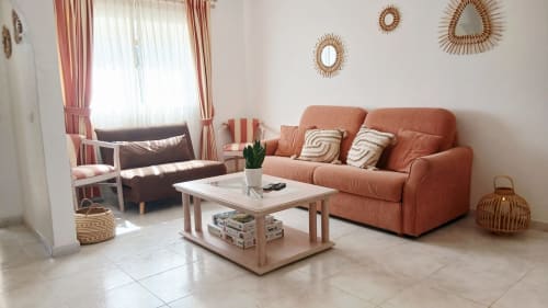 Sala de estar moderna do apartamento Sweet Home Oasis Parque em Portimão com sofá coral, mesa de café de madeira e parede contemporânea
