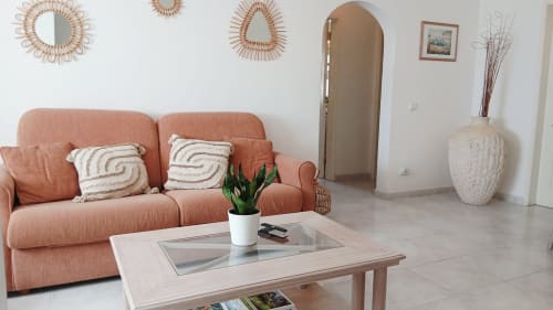 Sala de estar moderna do apartamento Sweet Home Oasis Parque em Portimão com sofá em terracota, mesa de madeira clara e espelhos decorativos