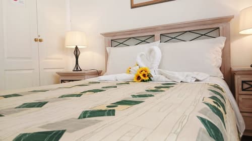 Quarto no Sweet Home Oasis Parque, Portimão com almofadas brancas, roupa de cama verde e decoração de girassol