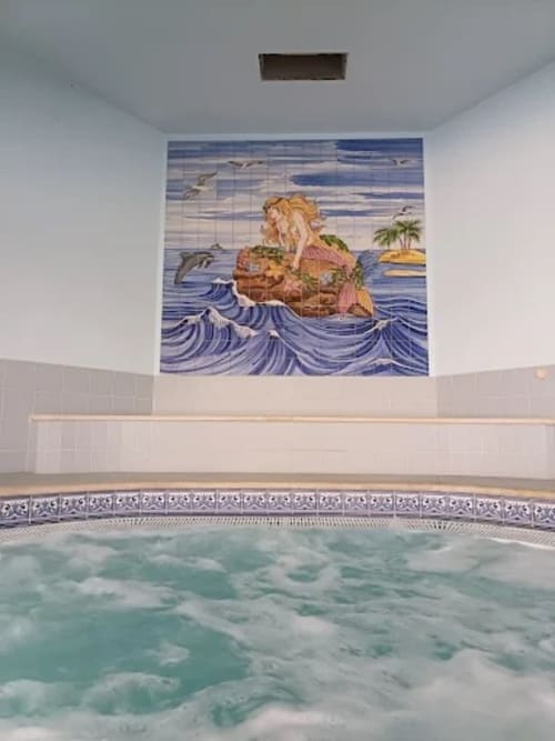 Área com jacuzzi e piscina do Sweet Home Oasis em Portimão com mural decorativo de sereia na parede