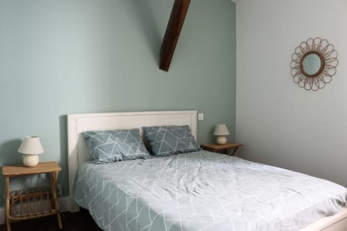 Modern bedroom at La Maison d'Augustin BnB in Mont-de-Marsan with queen bed, geometric bedding, sage green walls, wooden