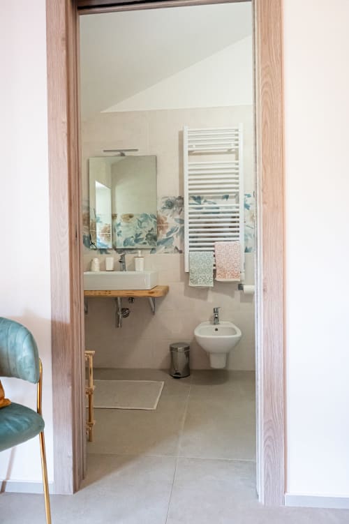 Bagno moderno della suite Calendula presso AgriBio Villa Ribes ad Altamura, con lavabo bianco, bidet e scaldasalviette