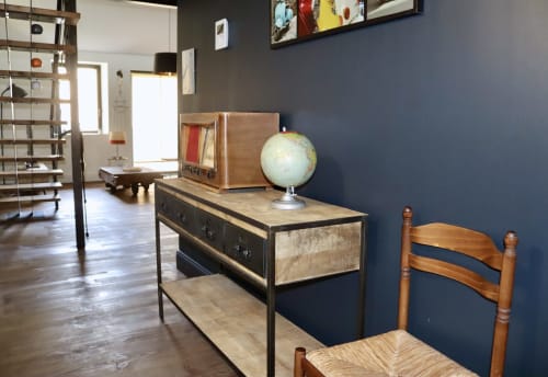 Contemporary loft interior at La Maison d'Augustin in Mont-de-Marsan with vintage desk, globe, wooden chair, and blue accent