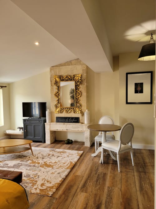 Elegant studio at Pavillon Des Millesimes with fireplace, ornate mirror, dining table, and cream decor in Lussac