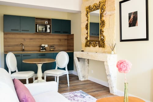 Deluxe studio at Pavillon Des Millesimes, Lussac with teal kitchenette, fireplace, round dining table, and white chairs