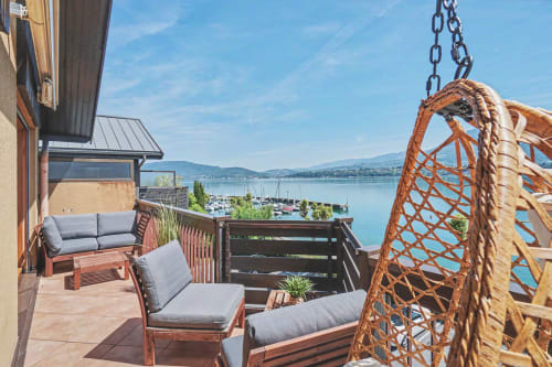 Lakeside apartment balcony at Emmlea with lounge chairs, rope swing, and panoramic lake views, Tresserve
