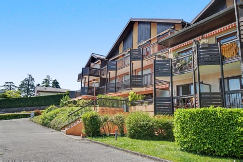 Emmlea hotel apartment building in Tresserve with modern balconies, landscaped grounds, and lakeside setting