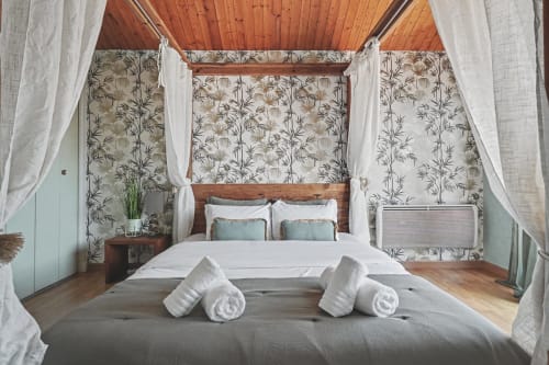 Luxurious canopy bed with white curtains in Le Lac Suspendu apartment at Emmlea, Tresserve, with lake view and rolled towels