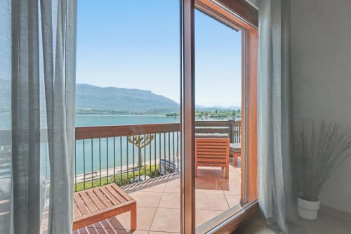 Lake view from balcony at Emmlea hotel in Tresserve, with mountains and turquoise water visible