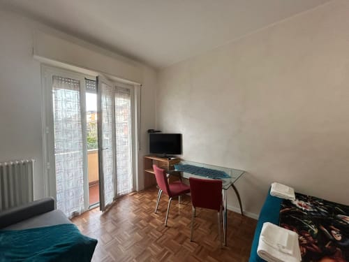 Modern studio apartment at Villa Marisa Pavia with desk, TV, balcony access, and garden view