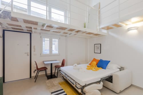 Camera da letto loft moderna a Milano con letto, scrivania e vista sulla città presso l'hotel Solumnia