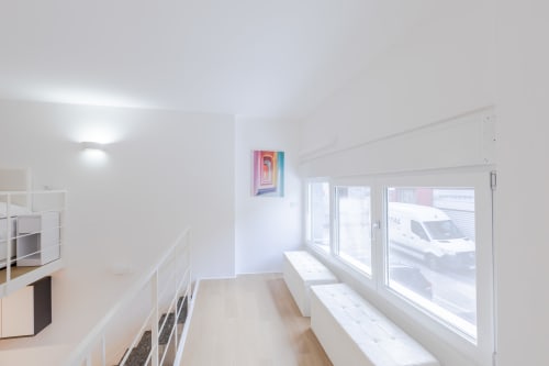 Luminoso loft moderno a Milano con vista sulla città, cucina minimalista, ringhiere bianche e ampie finestre sulla strada
