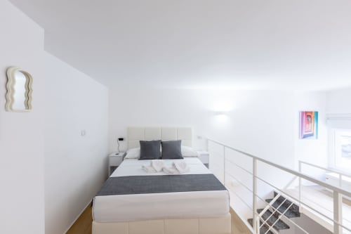 Moderna camera loft a Milano con letto queen, vista sulla città e soppalco presso l'hotel Solumnia