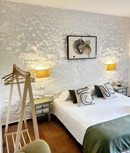 Cozy bedroom at Mas Ribas Hotel, Palamos with white stone walls, wooden furniture, and modern art decor