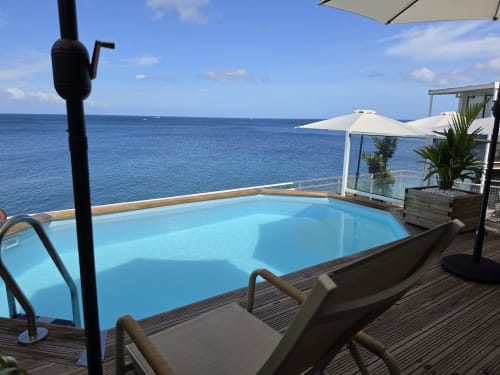 Terrasse de la maison Clémara Evasion avec piscine bleue donnant sur la mer des Caraïbes à Schœlcher, Martinique