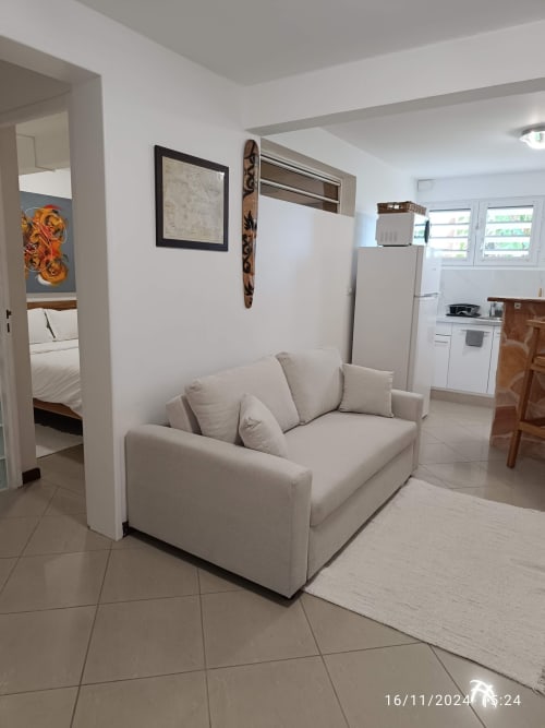 Séjour lumineux avec canapé beige, cuisine et chambre au gîte Clémara Evasion en Martinique